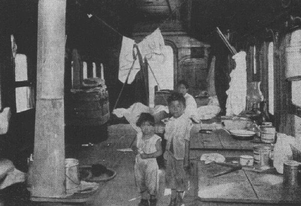 AN IMMIGRANT RAILWAY WORKER LIVES IN THIS CAR WITH HIS WIFE, SIX
CHILDREN, AND THREE DOGS