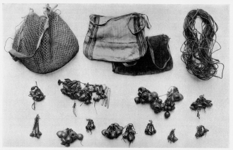 Fig. 23&mdash;Ornaments and fabrics of the Machiganga Indians
at Yavero. The nuts are made up into strings, pendants, and heavy
necklaces. To the left of the center is one that contains feathers and
four drumsticks of a bird about the size of a small wild
turkey&mdash;probably the so-called turkey inhabiting the eastern mountain
valleys and the adjacent border of the plains, and hunted as an
important source of food. The cord in the upper right-hand corner is
used most commonly for heel supports in climbing trees. The openwork
sack is convenient for carrying game, fish, and fruit; the finely woven
sacks are used for carrying red ochre for ornamenting or daubing faces
and arms. They are also used for carrying corn, trinkets, and game.