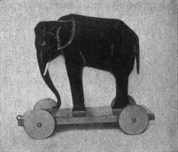 Elefant aus Holz, auf einen
  kleinen Wagen montiert